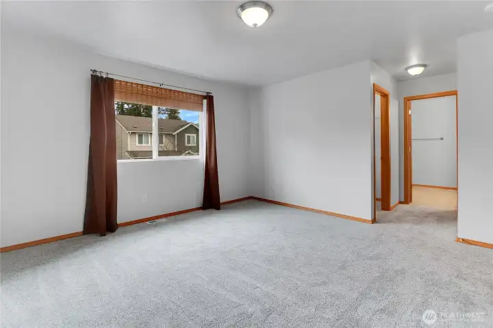 Primary bedroom with walk in closet, new carpet, and en-suite bathroom!