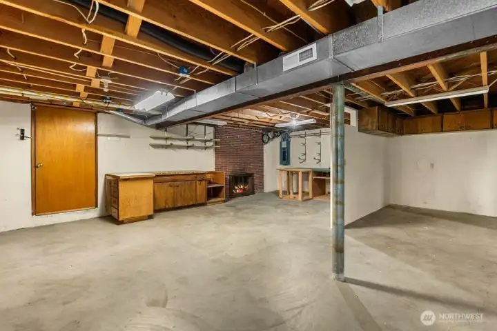 Unfinished basement with brick fireplace