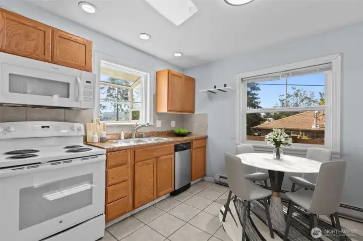 Virtually staged kitchen and dining area featuring abundant natural light, ceramic tile flooring, functional layout and space for everyday dining and entertaining.