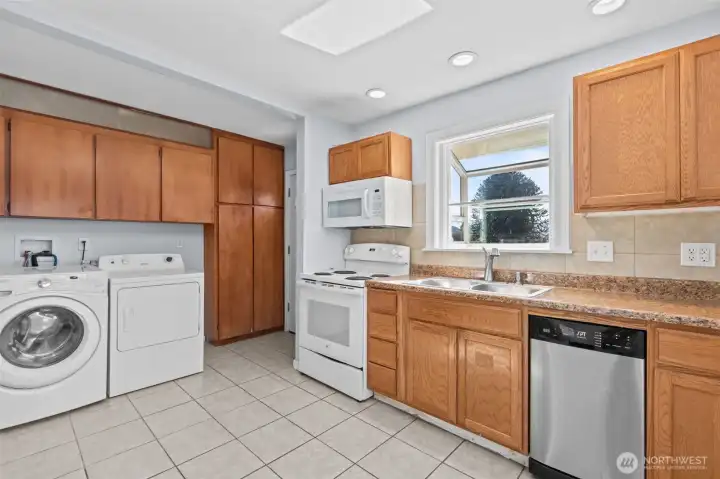 Functional kitchen with abundant cabinet storage, ceramic tile flooring and convenient in-home laundry area.
