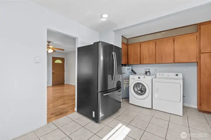 Functional kitchen and utility area with ceramic tile flooring, generous storage and full-size washer and dryer included.