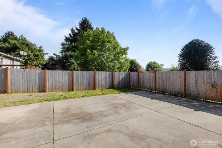 Expansive fully fenced backyard with oversized paved area offering endless possibilities for entertaining, recreation, additional parking or future potential.