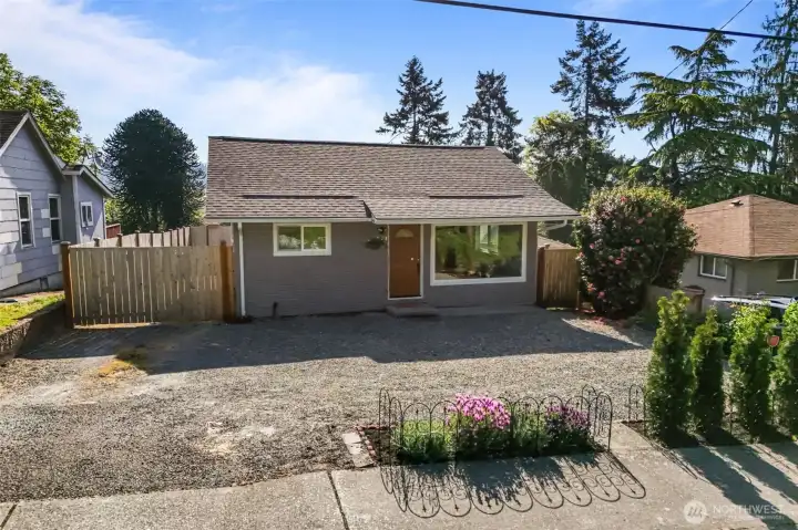 Inviting front exterior showcasing updated curb appeal, spacious off-street parking and a fully fenced setting in a convenient Renton location.