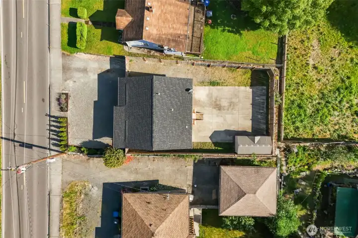 Aerial view showcasing the spacious lot, oversized paved parking area, fully fenced backyard and exceptional flexibility this property has to offer.