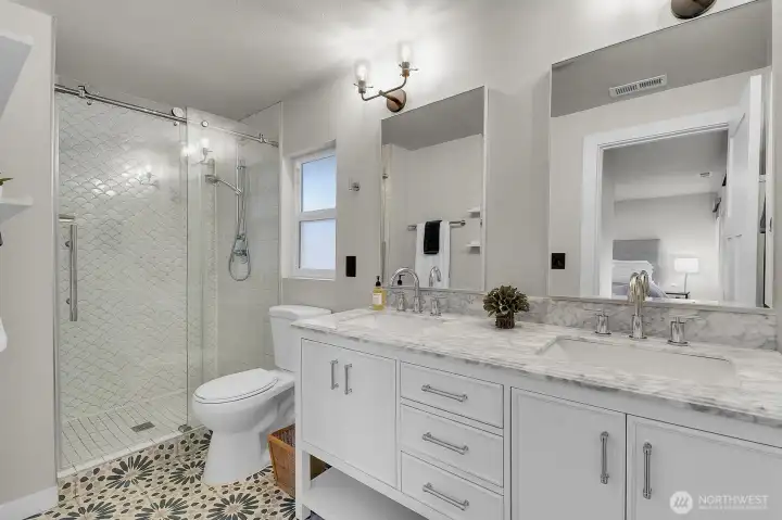The primary bath includes double sinks and a glassy walk-in shower.