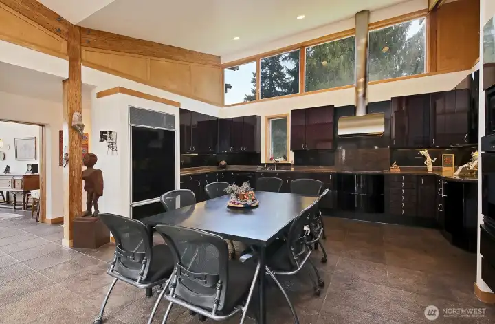 Grand eat-in kitchen with soaring ceiling and architectural interest.