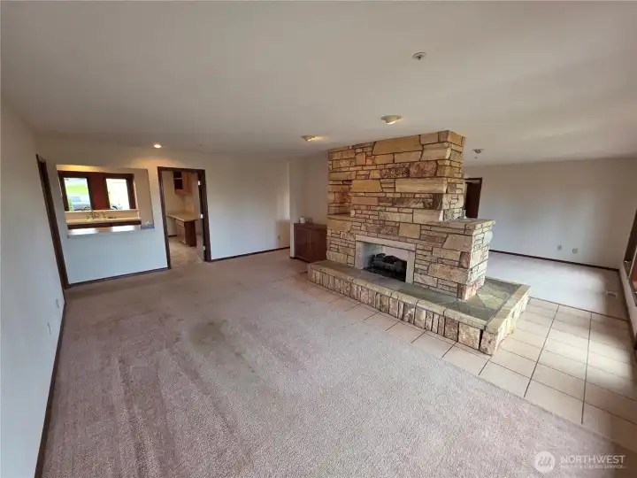 One side of the double living room with fireplace and looking into kitchen. One side of the double living room with fireplace and looking into kitchen.