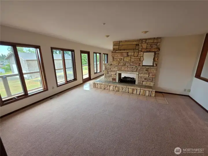 Other side of the living room with the double fireplace and views. Door exits to large deck. Other side of the living room with the double fireplace and views. Door exits to large deck.