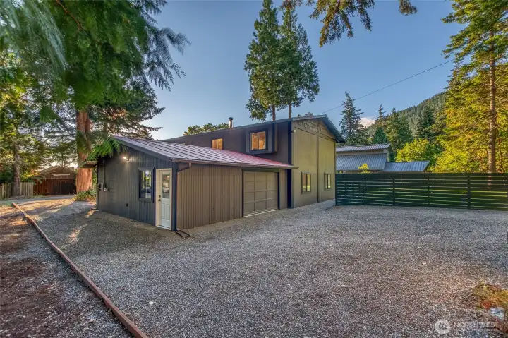 Newly regraveled driveway with ample parking, attached 2-car garage, and new privacy fencing.
