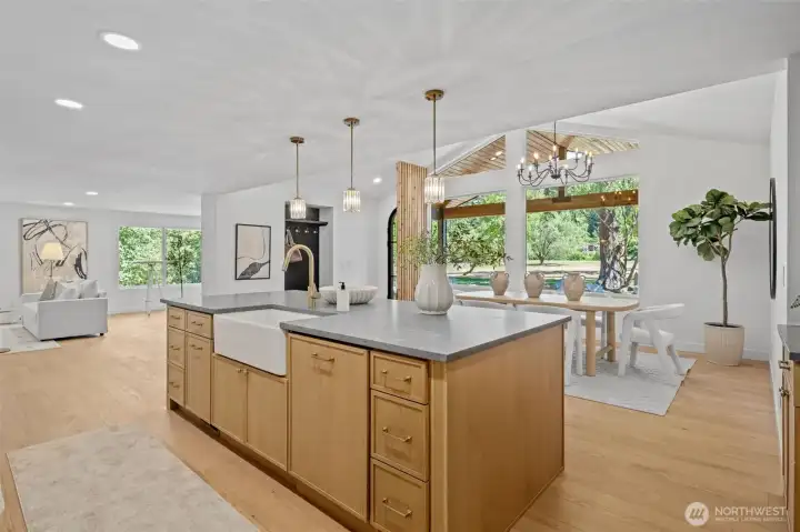 This kitchen island features a farmhouse apron sink and honed stone counters at its center. The open layout flows straight into the dining and living areas beyond. This kitchen island features a farmhouse apron sink and honed stone counters at its center. The open layout flows straight into the dining and living areas beyond.