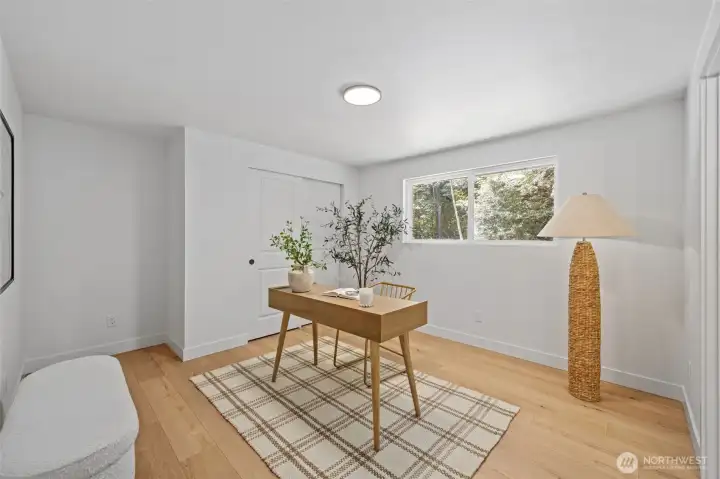 Bedroom Two features a sliding closet door and a window overlooking the wooded backdrop, filling the space with natural light. Wide-plank engineered hardwood and a fresh, neutral palette make it equally suited for a guest room or home office. Bedroom Two features a sliding closet door and a window overlooking the wooded backdrop, filling the space with natural light. Wide-plank engineered hardwood and a fresh, neutral palette make it equally suited for a guest room or home office.
