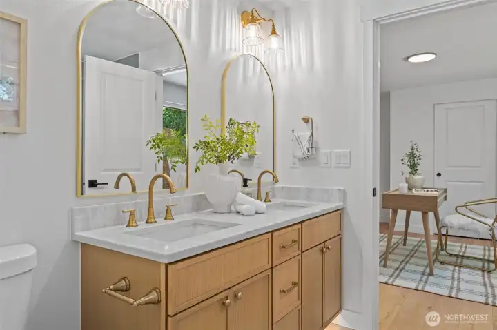 Connecting bedrooms two and three, this Jack and Jill bathroom features a dual-sink vanity with quartz countertops, arched brass-framed mirrors, and matching brass fixtures throughout. Wall-mounted sconces add a polished touch, making morning routines effortless for the whole household. Connecting bedrooms two and three, this Jack and Jill bathroom features a dual-sink vanity with quartz countertops, arched brass-framed mirrors, and matching brass fixtures throughout. Wall-mounted sconces add a polished touch, making morning routines effortless for the whole household.