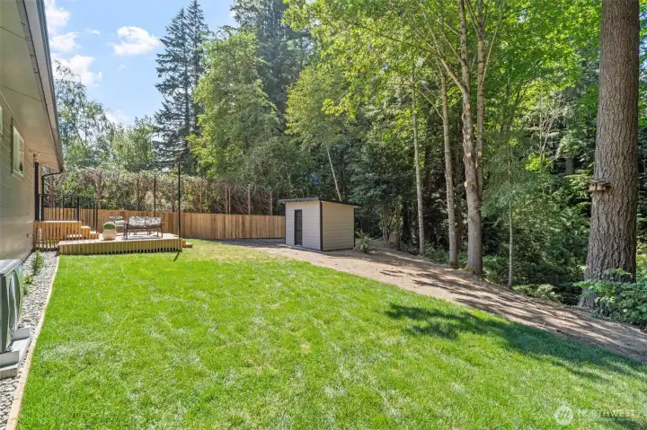 A sprawling lawn is framed by mature trees and a cedar privacy fence, offering plenty of room to play, garden, or simply unwind. The well house sits tucked at the edge of the property, blending seamlessly into the wooded backdrop while keeping essential systems out of sight. A sprawling lawn is framed by mature trees and a cedar privacy fence, offering plenty of room to play, garden, or simply unwind. The well house sits tucked at the edge of the property, blending seamlessly into the wooded backdrop while keeping essential systems out of sight.