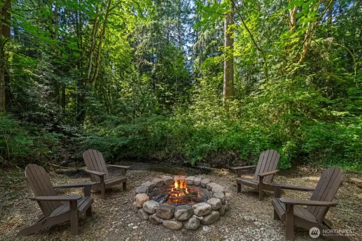 A secluded corner of the backyard sits tucked along a natural creek, framed by towering evergreens and lush woodland. This peaceful setting offers the perfect spot to create a private firepit or gathering area of your own.(Virtually Staged) A secluded corner of the backyard sits tucked along a natural creek, framed by towering evergreens and lush woodland. This peaceful setting offers the perfect spot to create a private firepit or gathering area of your own.(Virtually Staged)