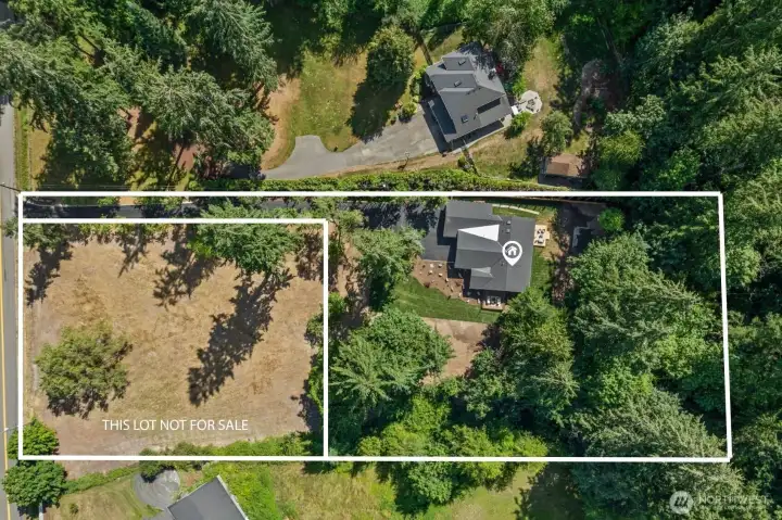The outlined image highlights the approximate property boundaries, with the adjacent lot clearly marked as not included in the sale. Mature trees surround the home, creating privacy while showcasing the generous homesite and outdoor space. The outlined image highlights the approximate property boundaries, with the adjacent lot clearly marked as not included in the sale. Mature trees surround the home, creating privacy while showcasing the generous homesite and outdoor space.