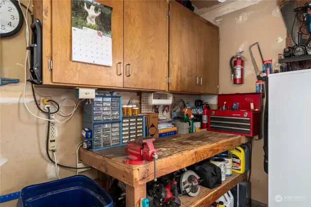 Work space/bench in garage with extra overhead storage.