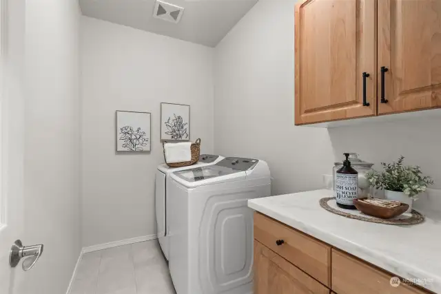 Laundry room with updated counters as well on main level, across from powder bathroom next to kitchen.