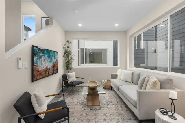 This light-filled living room is the perfect spot to kick back and relax! Thoughtfully designed with oversized windows, clean, modern finishes, and a cozy yet stylish ambiance, it's a space that feels like home.