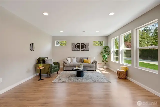 The living room features plenty of windows, creating a warm and inviting space with morning sunlight.