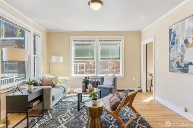Light-filled corner unit with tall ceilings, crown molding, and timeless charm throughout.