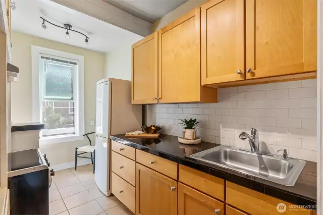 Cozy kitchen featuring tall ceilings, natural light, and plenty of storage—perfect blend of classic and practical.