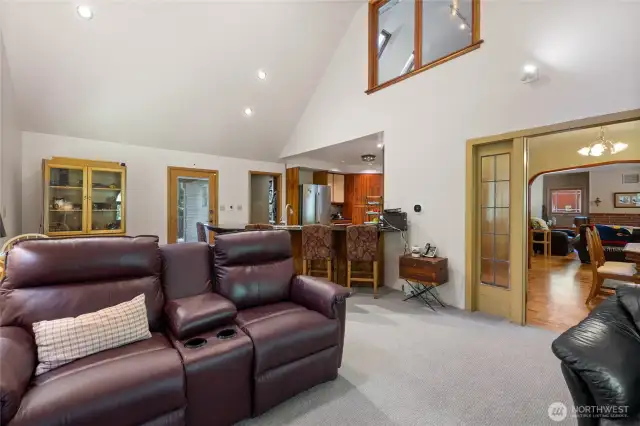 This open concept space contains the family room, an eating nook, kitchen, and a loft window to the primary.