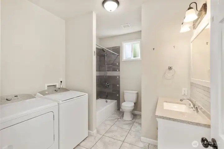Full bathroom with laundry area