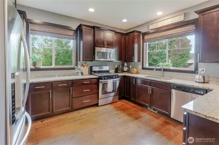 Another angle of the thoughtfully designed kitchen, where natural light, rich cabinetry, and stainless-steel appliances come together to create a space that’s both functional and inviting