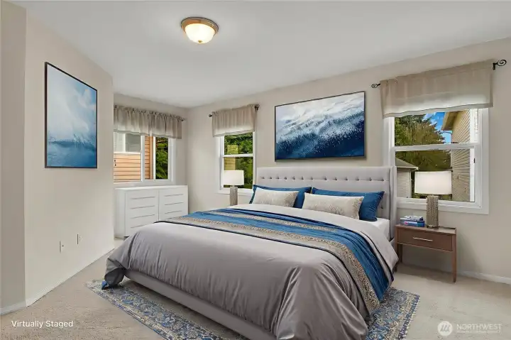 Virtually staged primary bedroom has lots of natural light coming in from the 3 windows.
