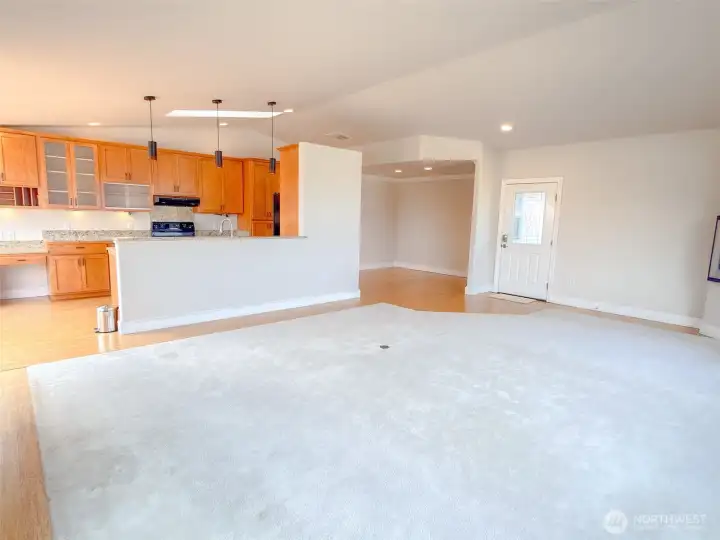 Looking from the corner of the living room back to the kitchen, formal dining area and front door.