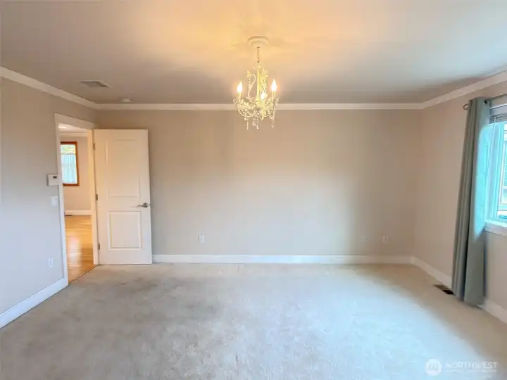 Roomy primary bedroom, showing entry door from the hallway.