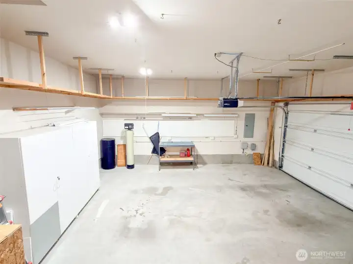 Attached garage has many storage shelves, cabinets, work bench, water softener, garage door opener, and room for 2 vehicles.