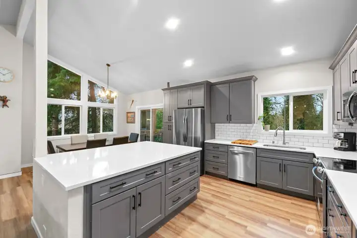 At the heart of the gourmet kitchen, a large island with a quartz countertop offers abundant cabinet and drawer storage, combining style and function.
