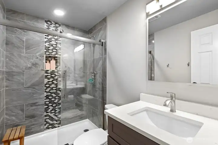 The primary suite boasts a stylishly updated bath with modern finishes.