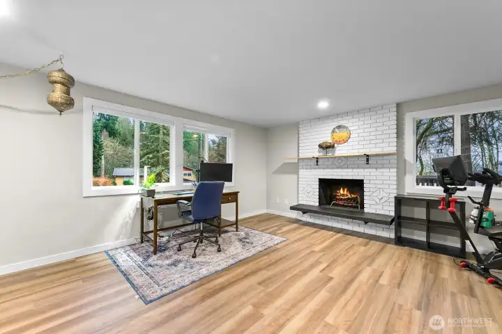 The lower-level family room is bright and welcoming, featuring a second fireplace and large picture windows that flood the space with natural light.