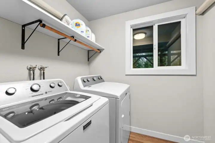 The lower level offers a roomy walk-in laundry with full-sized washer and dryer, plus a window for added light.