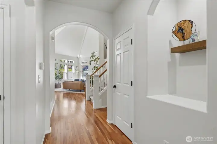 Hallway view from family room to entry/Living Room. The art nook is a great touch, one of several hall closets and your stairs up to your right. Look how light and bright this home is!
