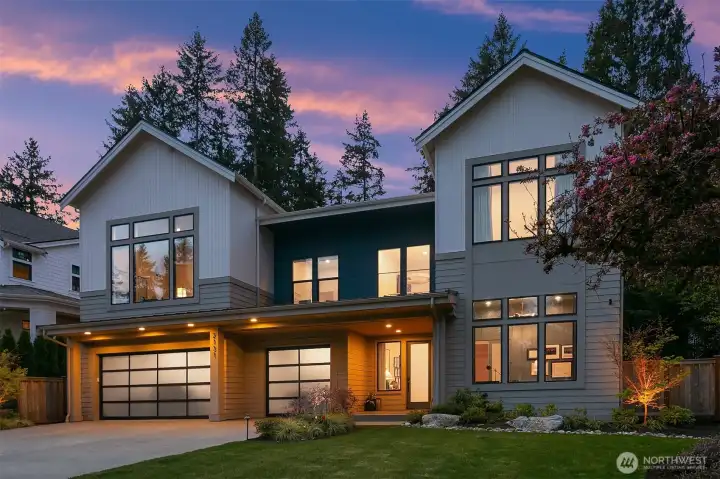 Glass-panel garage doors, bold accents, and a three-car garage with 50-amp EV charger — the curb appeal that holds up just as well after dark as it does in daylight.