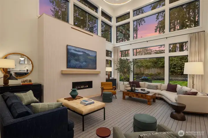 Floor-to-ceiling fluted tile, a linear gas fireplace with floating wood mantle, and a wall of glass bringing the garden and evening sky inside. The kind of room that makes you want to pour a glass of wine and stay a while.