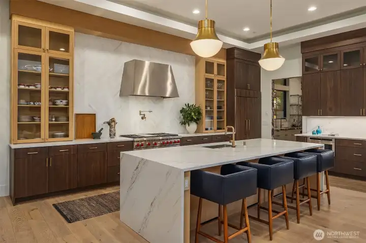 Every finish earns its place — two-toned cabinetry, Brizo Luxe Gold pot filler, Sub-Zero column refrigerator, and a 48" Wolf range with enough BTUs to mean it. The kitchen serious cooks dream about.