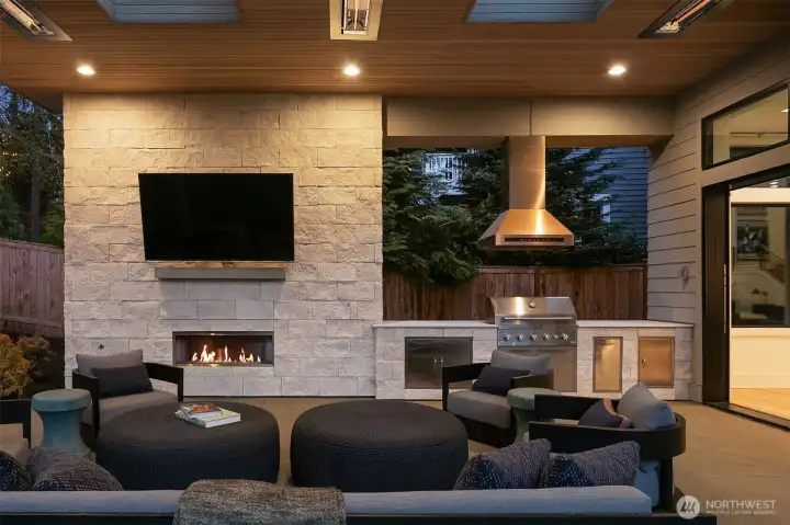 Floor-to-ceiling stacked stone, a linear gas fireplace, and a fully outfitted outdoor kitchen with professional-grade grill. Every detail designed for the nights you don't want to end.