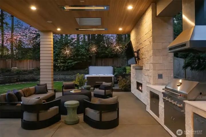 Cedar-clad ceiling, infrared heaters, built-in BBQ, outdoor fireplace, and a hot tub beyond — all under a Pacific Northwest sunset. Built not for occasional use, but for the rhythm of daily life outdoors.