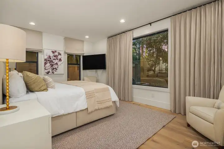 A well-appointed main-floor guest suite with linen drapery, wide-plank white oak floors, and its own private outdoor access. Guests arrive as visitors and leave wishing they could stay longer.