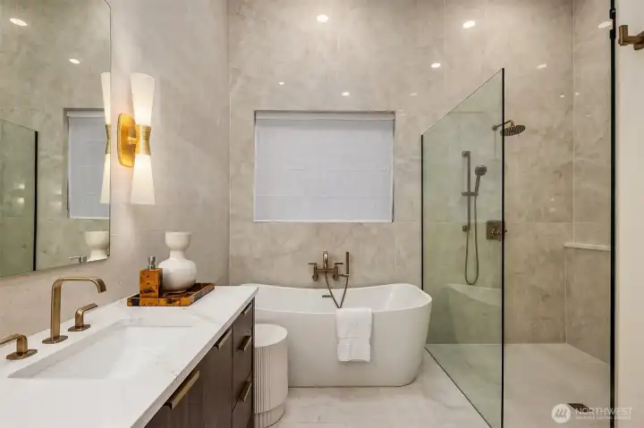 The complete picture — Opalite slabs from floor to ceiling, freestanding soaking tub, rain shower, Brizo Allaria Luxe Gold, and heated floors underfoot. A bath that earns the word retreat.