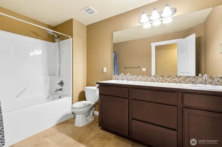 Full hallway bath, with two sinks w/tiled back splash, and vinyl tiled floor plus shower/bathtub combo. Full hallway bath, with two sinks w/tiled back splash, and vinyl tiled floor plus shower/bathtub combo.