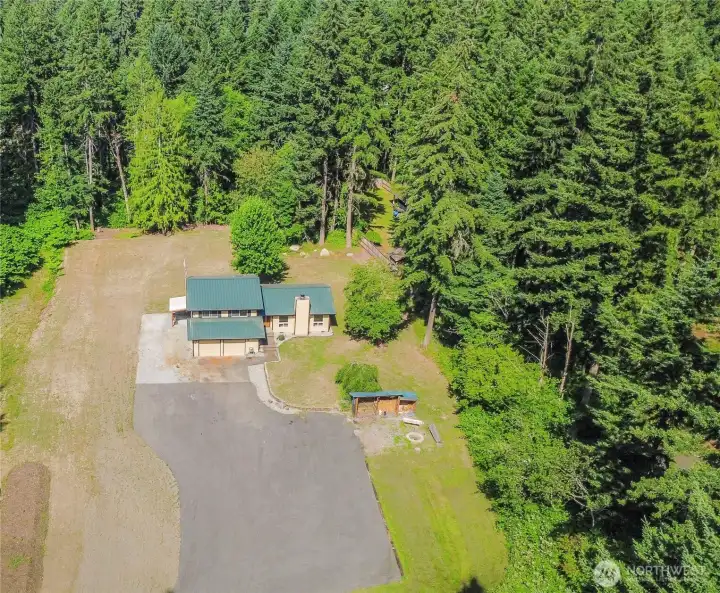 Sprawling 1.22-acre parcel showcasing ample usable space, RV parking, and room for a future shop with a private, wooded backdrop.