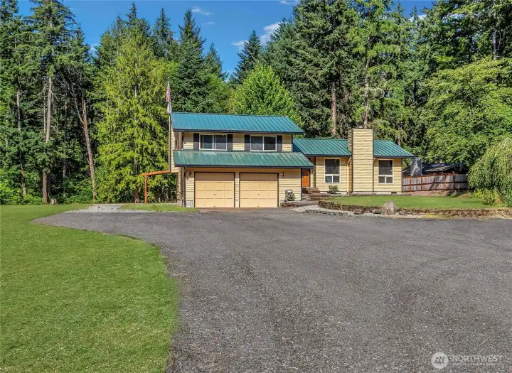 Secluded setting at the end of a dead-end road offering privacy, mature surroundings, and a peaceful country feel just minutes from town. Grass digitally enhanced to show potential.