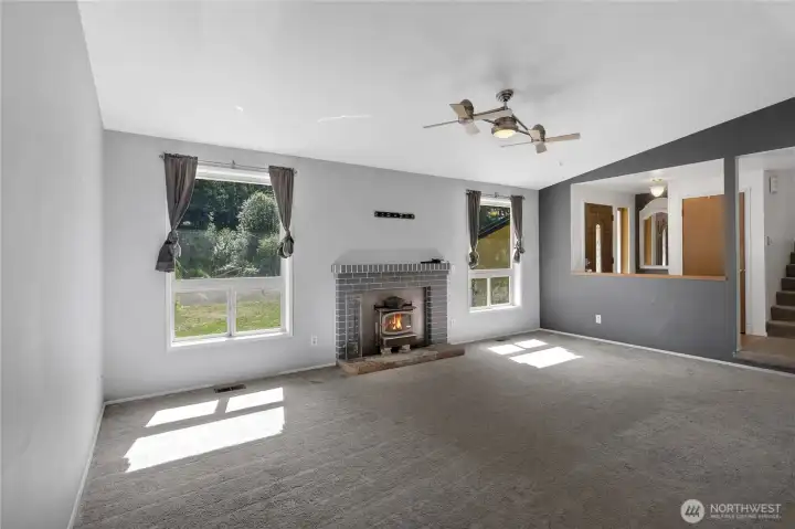 Comfortable main living area featuring a cozy wood-burning fireplace, large windows, and a warm, inviting layout.