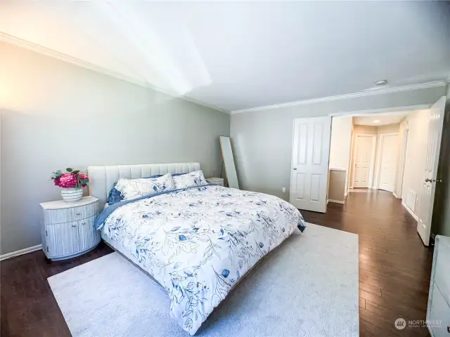 Spacious and light primary suite through French doors. Look at how small the KING sized bed looks in this room!