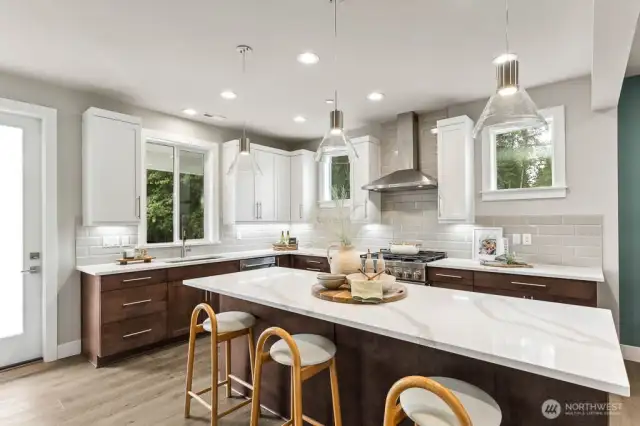 Slab quartz countertops, full height backsplash, huge island for entertaining, 42" upper cabinets with soft close hinges and undercabinet lighting.  Gas cooking and modern pendant lighting!